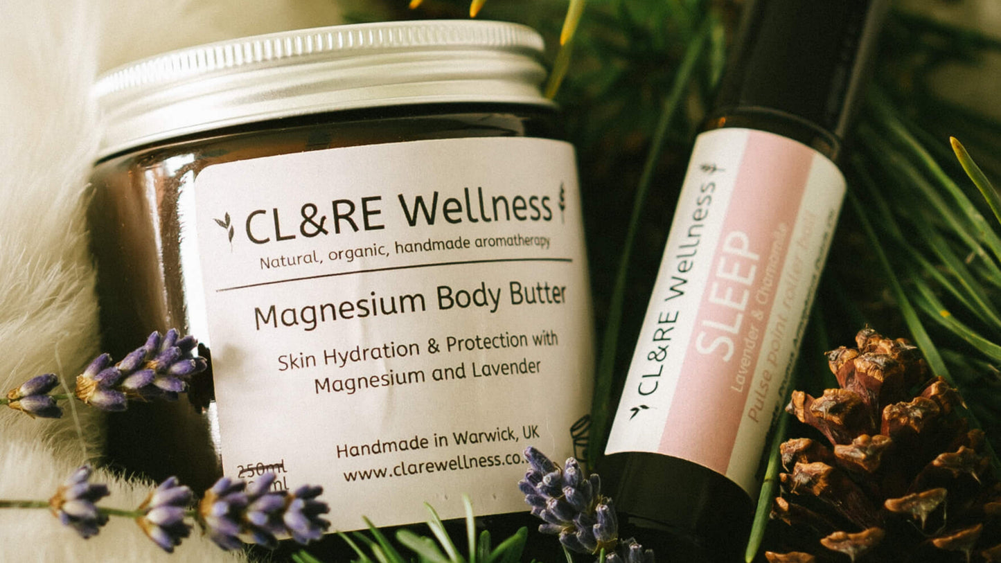 CL&RE Wellness magnesium body butter and sleep rollerball on a decorative background with greenery and lavender.
