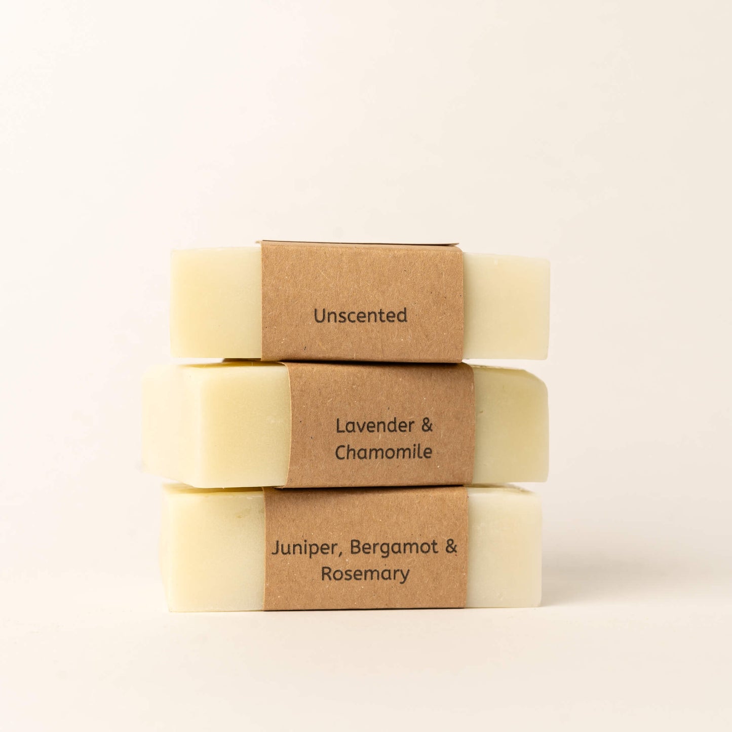 Three CL&RE Wellness facial cleansing bars with Unscented, Lavender & Chamomile and Juniper, Bergamot & Rosemary labels on a plain background