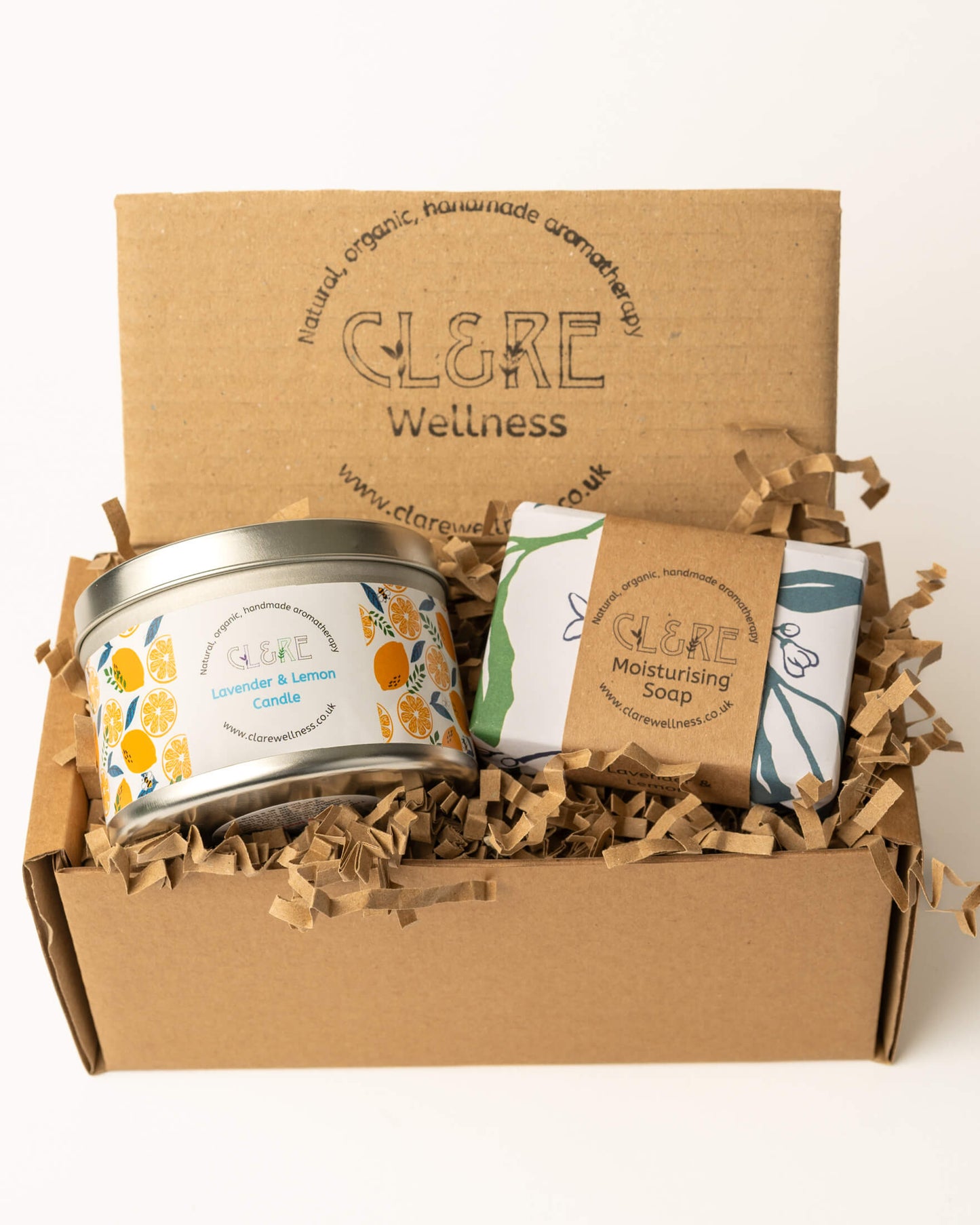 Box of CL&RE Wellness Lavneder & Lemon products including a candle and soap bars on a white background