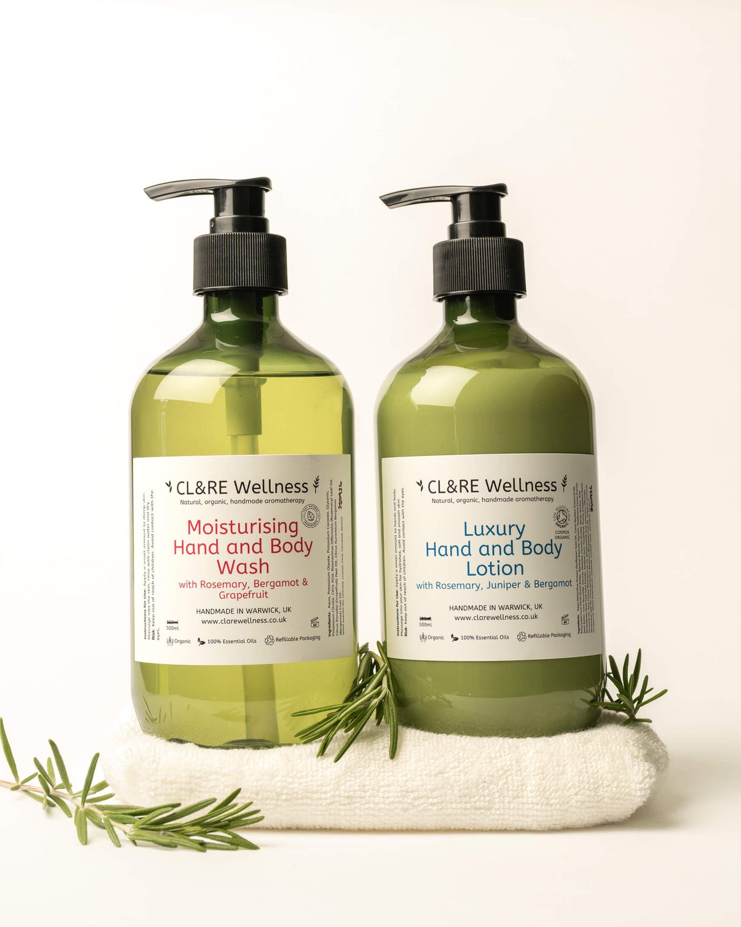 2 green bottles of CL&RE Wellness Moisturising Hand & Body Wash and Luxury Hand & Body Lotion on a white flannel with herbs.