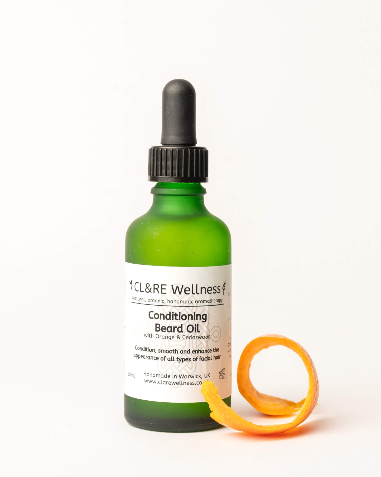 Green bottle of CL&RE Wellness Conditioning Beard Oil with Orange & Cedarwood with a dropper on a white background
